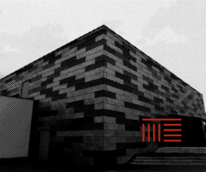 Façade en briques noires avec motif géométrique.